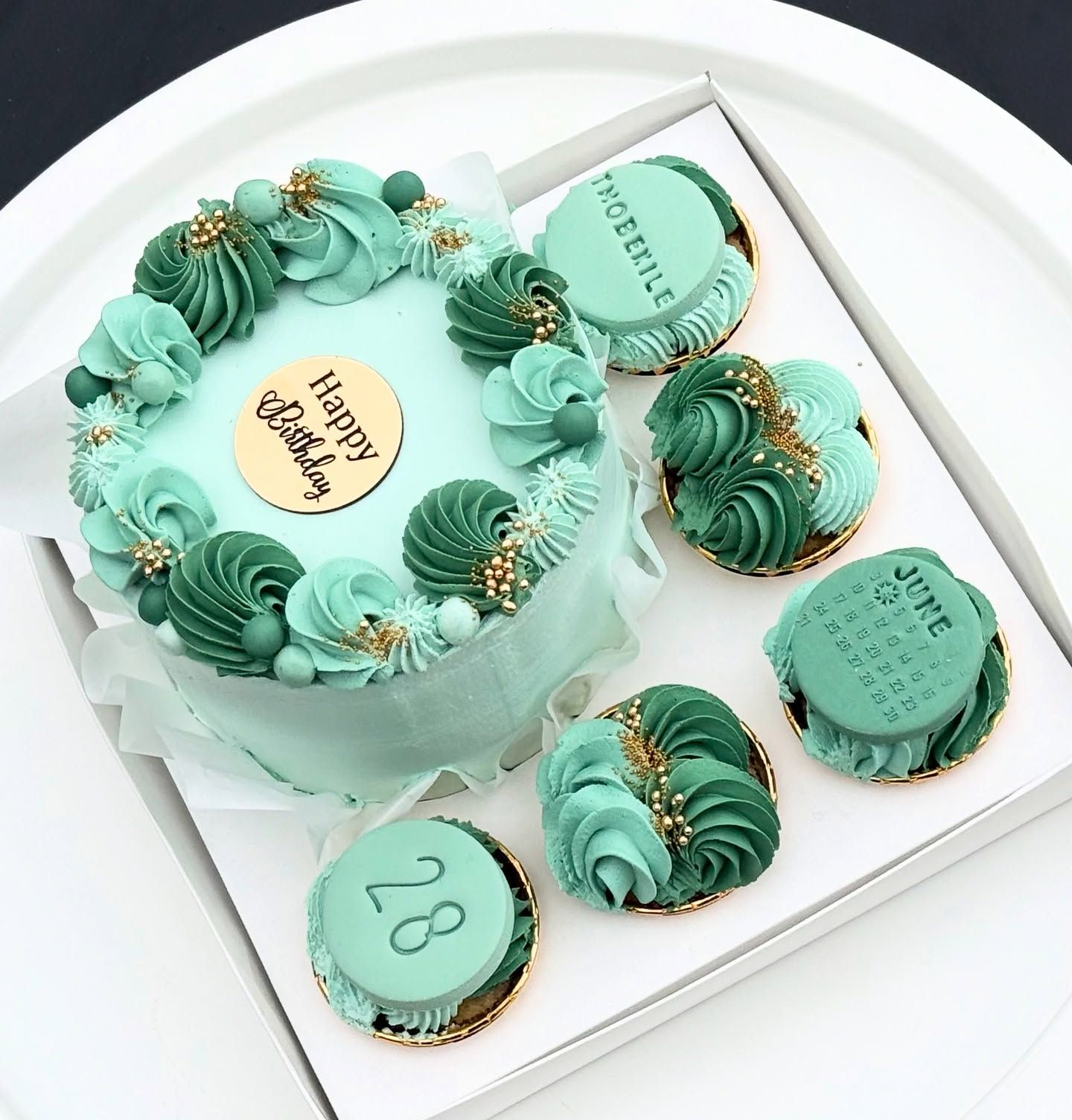 Mint-green celebration cake with matching cupcakes
